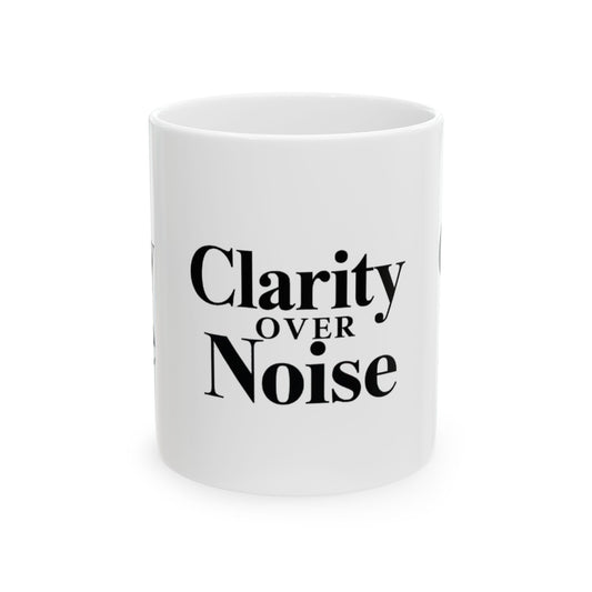 White mug with 'Clarity Over Noise' text on a white background Motivational trading mug next to stock market book on desk with laptop and charts